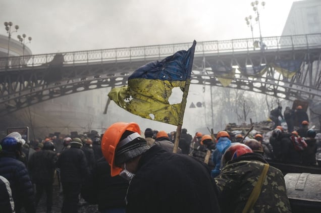 Сlashes between riot police and protesters during the attempting to block Verhovna Rada. A man with tattered Ukrainian flag on Institutska street. In 20 minutes snipers opened fire. Kiev, Feb. 20, 2014