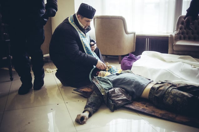 Priest make a funeral service at a field hospital in the hotel Ukraine for a just killed protester by a sniper on Hrushevskoho street. Kiev, Feb. 20, 2014
