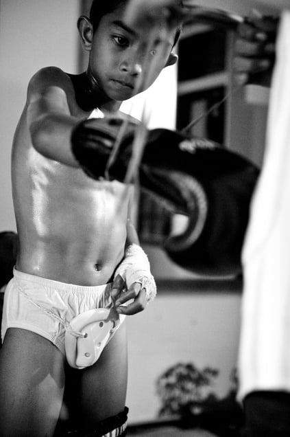 The coach binds a boy the boxing gloves. © Sandra Hoyn