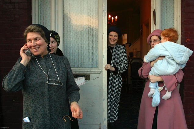 3 generations of women from the same family watch the Purim events from a safe distance. Purim is one of the most entertaining Jewish holidays.  It commemorates the time when the Jewish people living in Persia were saved from extermination from a massacre by Haman due to the courage of a young Jewish woman called Esther. It is customary for men dress up and to hold carnival-like celebrations.