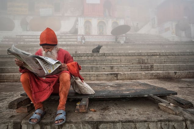 Varanasi, India: A Sadhu is reading daily news on the banks of holy river Ganges. © Matjaz Krivic