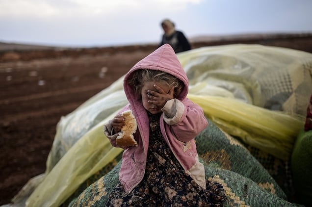 Near the southeastern town of Suruc, Sanliurfa province, Turkey, October 2, 2014. A Kurdish woman and her daughter wait after crossing from Syria into Turkey, with mortar fire on both sides. © Bülent Kiliç / AFP