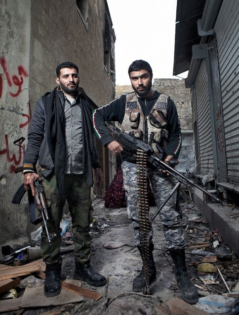 Two FSA rebels hold their weapons for a portrait near a front line checkpoint in the old city district of Aleppo on February 9, 2013. © Nish Nalbandian