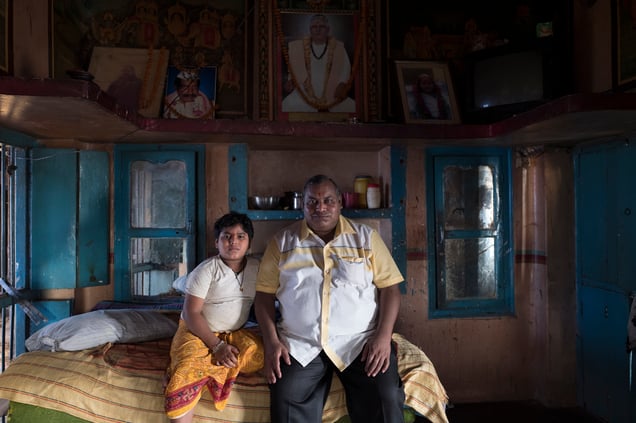 Gagdesh , the King of the untouchables or Dom Raja and his son, Om . They are surrounded by portraits of his ancestors who have been in charge of Manikarnika for generations.