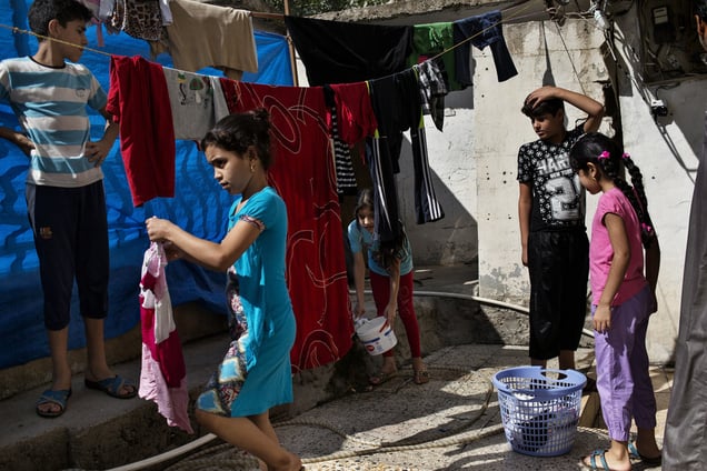 Displaced children from Falluja hang their washing on ropes outside the basement  where they have been living for the past year and a half. 11 families live in the building, each of them using a 3 by 4 meters' room for which they pay 300.000 IQD (250 USD). 29/08/15. Shaqlawa, Iraq.