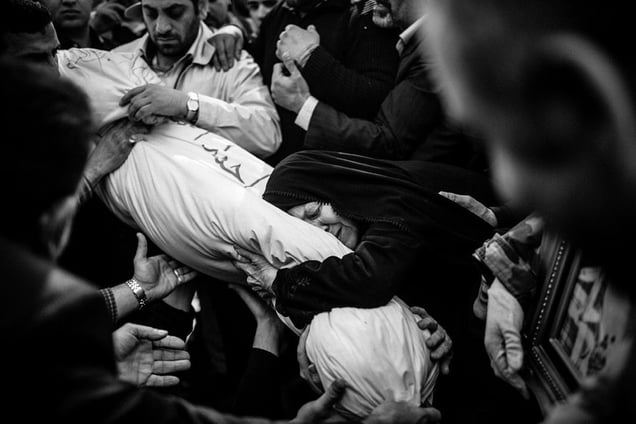 Eshrat Tabatabayee (72), the mother of Ahmad Afshar, embraces her son's body after 30 years of waiting. He was identified by his ID tag