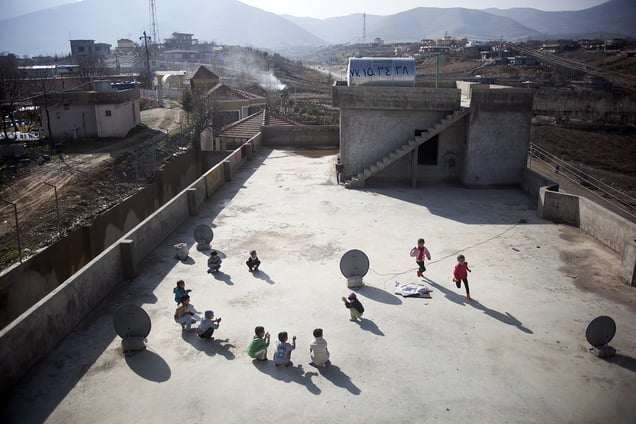 Children play on the rooftop of the unfinished building where they have been living with their families since August 2014, when they escaped from Sinjar. 01/02/15. Sitak, Iraq.