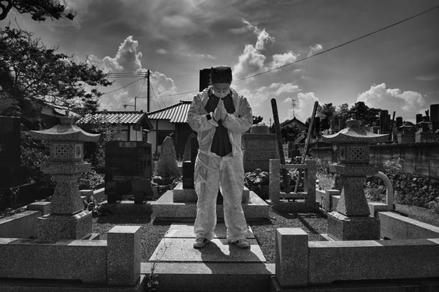 Mister Matsumoto, Yakuza member and TEPCO contractor is praying on his family grave, from the series Fukushima "No Go" Zone, © Pierpaolo Mittica.