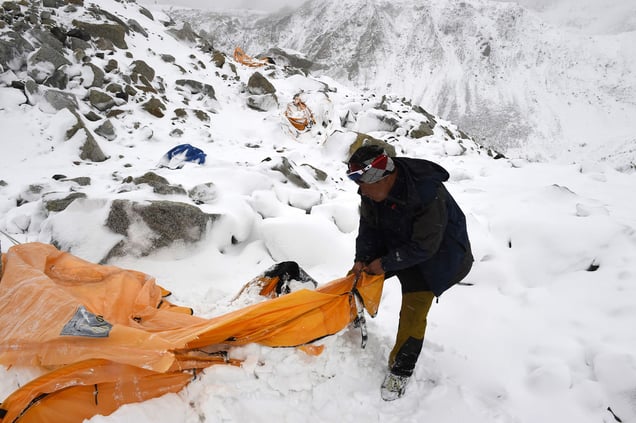 Trekking guide Pasang Sherpa searches for survivors among flattered tents moments after a wall of rock, snow and debris slammed on Everest Base camp.Nepal, 25 April 2015.