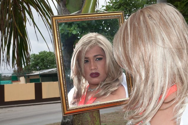 Anais De Trevis/ Arnoldo, performer, outside the apartment he shares with his partner, Enrique, Havana © Mariette Allen