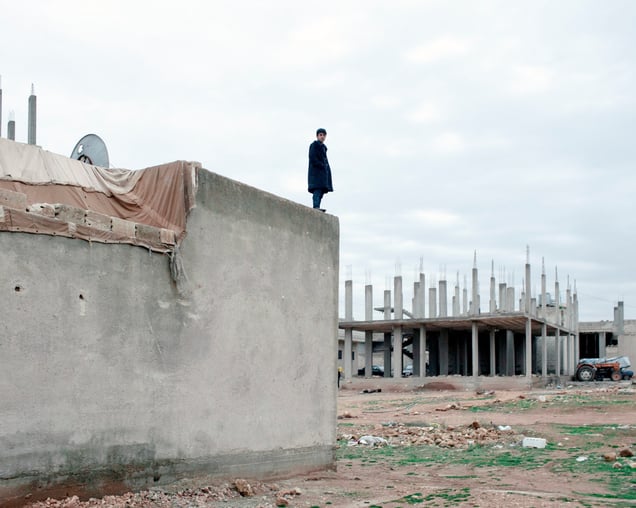 SYRIA. Ayn Al Arab. (Kurdish: Kobani / Kobane). December 2014. A civilian watching an airstrike.