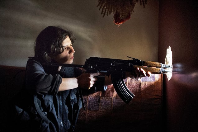 Rukan, a female YPG fighter and unit leader aims her weapon from a fighting position in the Sheikh Maqsood district in Aleppo on April 19, 2013. © Nish Nalbandian