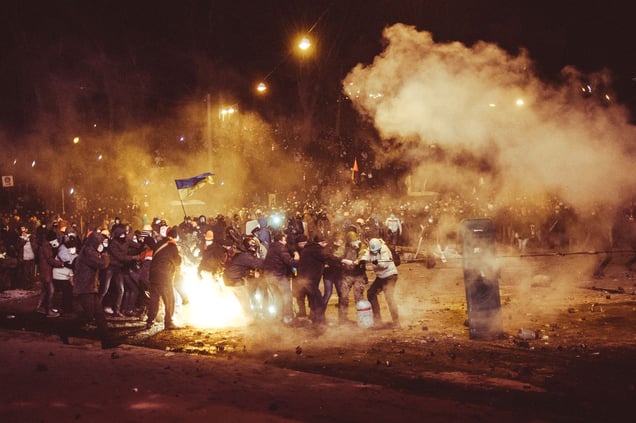 Protester try to clear the road and to take away burned bus on Hrushevskoho street under heavy fire of rubber bullets and stun grenades. Kiev, Jan. 19, 2014