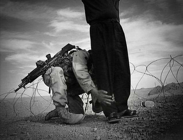 Eastern Iraq (2003). An Iraqi man is hand-searched by a U.S. soldier at an improvised check-point.