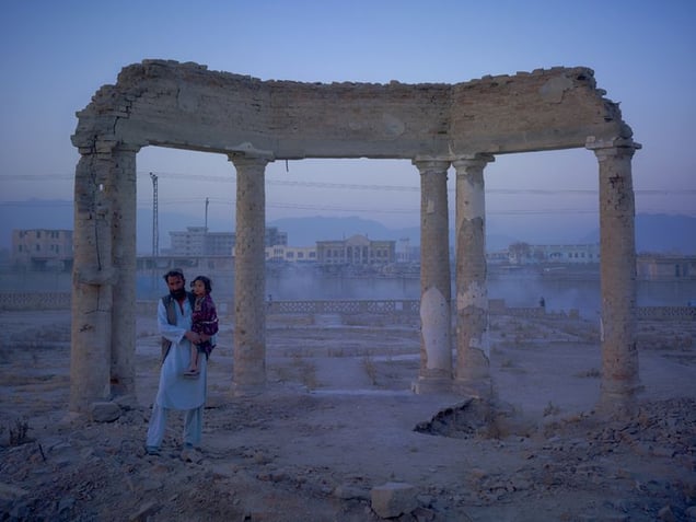 Jaw Aka Faizal Nahman and his daughter Nono from Bamiyan province, now living in an improvised plastic shelter in the ruined gardens of Darulaman Palace. Built in the 1920s to house an Afghan parliament, Darul Aman translates as abode of peace.© Simon Norfolk.