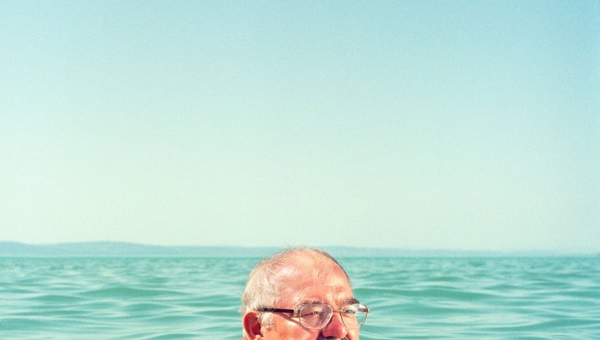 A man swims in Lake Balaton wearing an old wallet, a typical accessory in the 1970s.