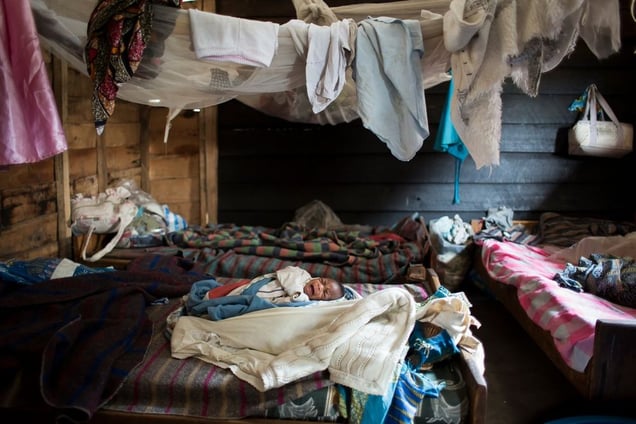 A 2-week-old infant cries in the shelter for victims of sexual violence in the village of Buganga, two miles south of Minova. Founded by activist Rebeca Masika Katsuva, a rape survivor herself, the center was home to more than 30 women and children during the attacks of November 2012. © Diana Zeyneb Alhindawi