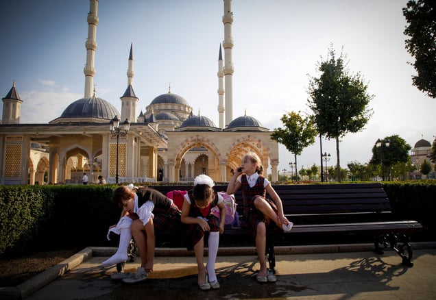 Chechen girls after school in front of the Heart of Chechnya mosque, the largest in Europe. All Chechen girls, despite religion, must wear a head covering in public schools and government buildings.