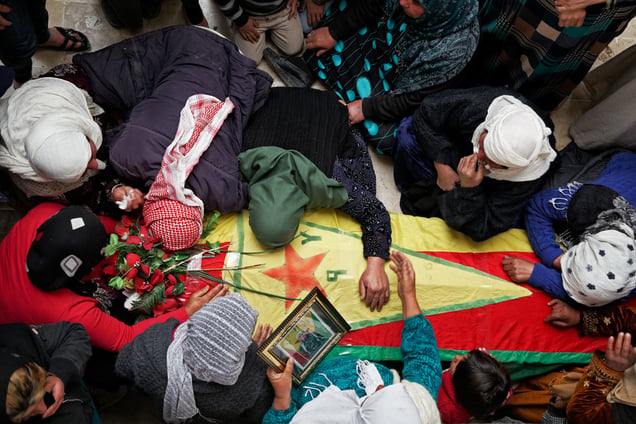 During a ceremony in Kobane, Syria, on 2 April, 2015, mourners gather by the coffin of their loved ones who were killed during clashes with the Islamic State in one of the frontlines of Kobane, Syria