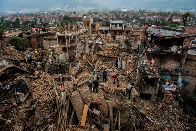 Residents forage through their destroyed homes, gathering salvageable belongings. Bhaktapur, Nepal, 29 April 2015.
