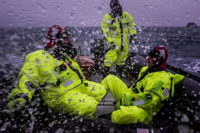 A Chilean scientist, supported by logisticians from the Chilean Antarctic Institute,are battered by waves on their way back to base after having taken sea-watersamples; Fildes Bay, Antartica, 02 December 2015.