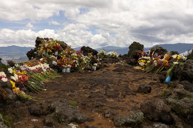 Flowers on the Almolonga volcano, also called Cerro Quemado, in Guatemala.The ancient Maya believed that volcanoes were holy places where the Gods and spirits resided. Cerro Quemado is considered one of the best places to get close to the Gods. Thats why people come from all over the region to pray and perform ceremonies, bringing flowers and sometimes food and alcohol to leave as offerings to God and the ancestors. Some people also believe that Juan Noj, a supernatural Maya being lives in the volcano.