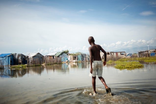 A boy walking through the flooded landscape at Rapatriès.
