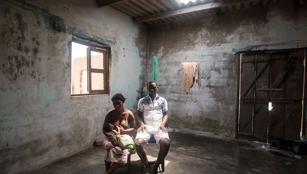 Agbavi, Togo. Komlan Setor (man), 27 and Adjo Setor, 25, sit in their house on the coastline of Agbavi. Due to the depletion of fish stocks, Komlan is struggling to feed his family and is now forced to work part-time as a tailor. With their house just on the shoreline, Komlan predicts his family will be forced to move in 6 months time.