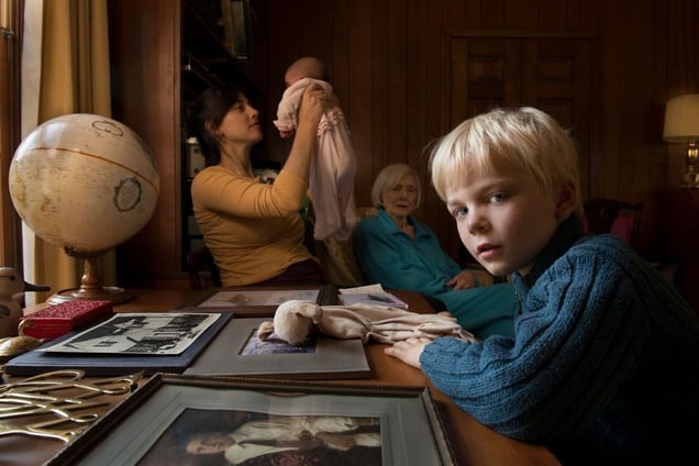My grandmother (background) had put out these family photographs during a visit. When my 5 year old turned to me, I knew I had something important. © Jessica Todd Harper. Finalist, LensCulture Portrait Awards 2014
