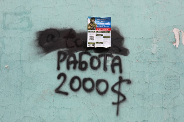 A military recruitment poster is seen near a train station in Irkutsk on May 13, 2024, advertising salaries for roles such as snipers and cooks—often several times higher than the local average income. Although many of these posters are torn down, new ones quickly replace them, appearing near train stations, on buses, and throughout public spaces.