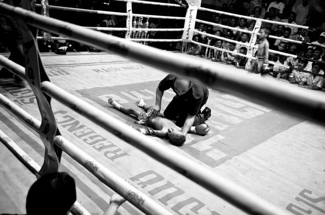 A boy  has lost the boxing match and is lying unconscious on the ground. © Sandra Hoyn