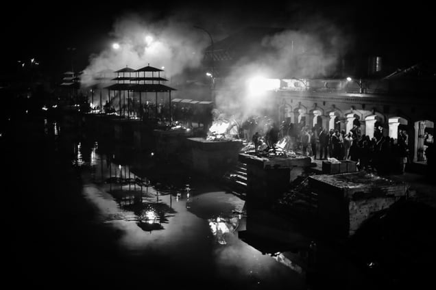The bodies being cremated at the Ghats of Pashupatinnath temple. The HIndus consider it sacred to be able to cremate their bodies of the deceased relatives by the side of Bagmati river. It is the site of grief and mourning for some while workplace for a few.