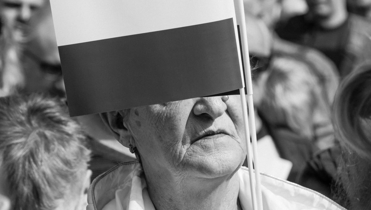A woman holding a Polish flag during a public gathering.