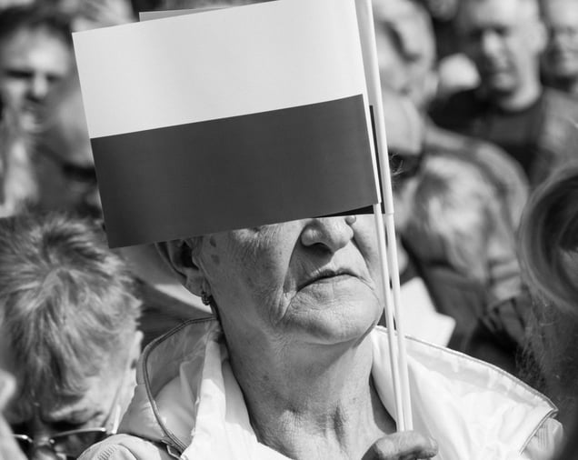 A woman holding a Polish flag during a public gathering.