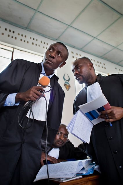 Defense lawyers listen to a testimony, compare notes and discuss their next response. © Diana Zeyneb Alhindawi