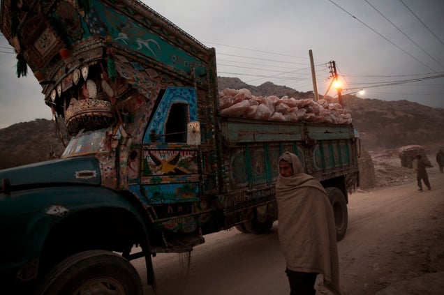 A salt miner and a truck laden with pink rock salt leave the Warcha salt mine at the end of the day