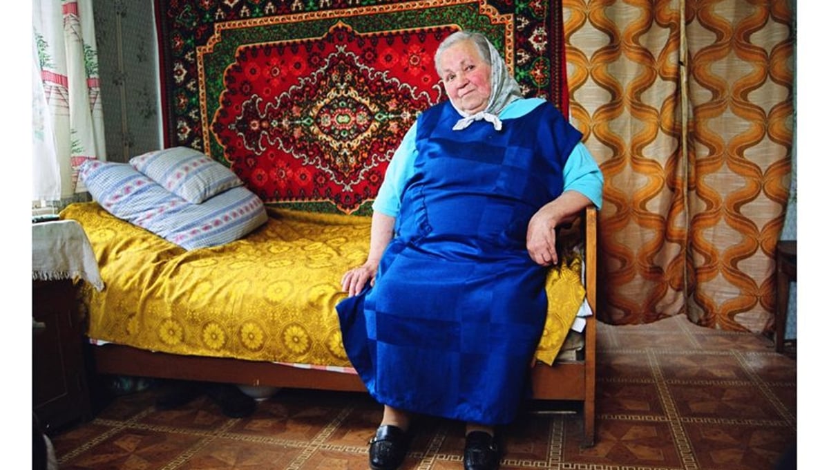 Antanina Kacuceviciene is all alone at home, after her children and grandchildren left looking for jobs in Spain, Portugal and England. She let a young family inhabit the first floor of her house in exchange for chopped firewood and water brought to the house, and she rented out a room with a door to the church square for a small shop that since went bankrupt. © Mindaugus Kavaliauskas
