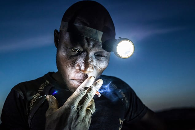 A mine worker takes a smoke break before going back into the pit. Miners in Bani face harsh conditions and exposure to toxic chemicals and heavy metals.Image taken in Bani, Burkina Faso, on 20 November 2015.