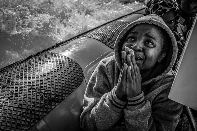 A Nigerian migrant prayers moments after being rescued