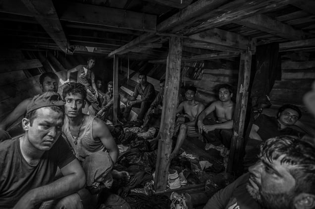 Bangladeshi and Pakistani migrants wait to be evacuated from the fetid hold of a smuggler boat off the coast of Libya