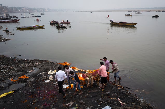 he chanting "Ram nam satya hai "(Truth is the name of Ram) announces the arrival of another mourning party. Wrap in an orange shroud and covered with a garland of flowers, the body of their loved one  travels through the city to Manikarnika in a bamboo bier.