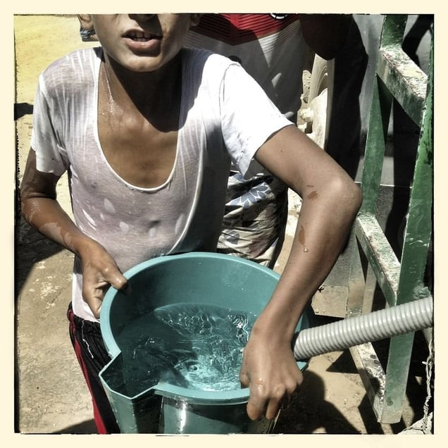 Once the water trucks have delivered water to the communal containers families use buckets to fill up for their use at home.