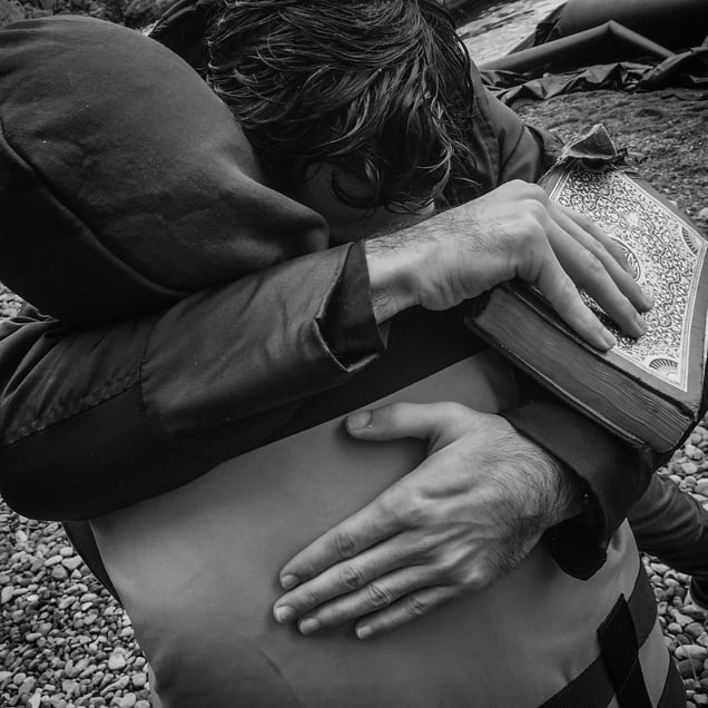Refugees embrace after landing by boat in Lesbos, Greece.