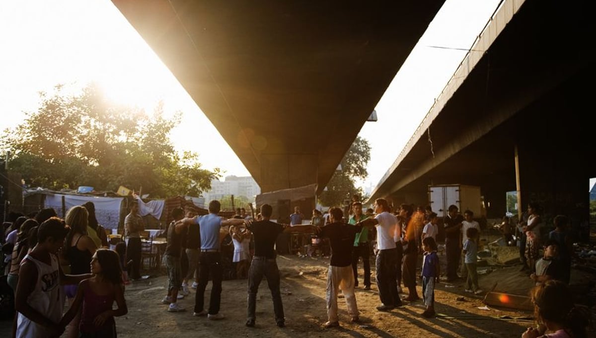 A late-summer party organized by a Roma family, refugees from Kosovo, under the Gazela bridge which flies over camps on both sides of the Sava river. The destruction of the camps is to make way for reconstruction of the old bridge. © Matt Lutton