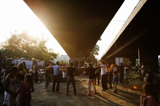 A late-summer party organized by a Roma family, refugees from Kosovo, under the Gazela bridge which flies over camps on both sides of the Sava river. The destruction of the camps is to make way for reconstruction of the old bridge. © Matt Lutton