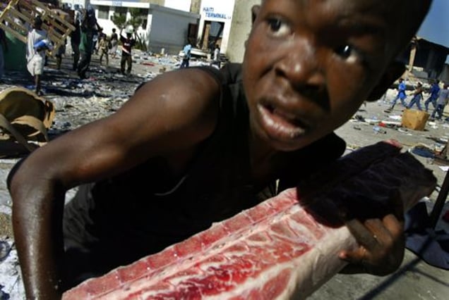 2nd prize Spot News Single © Shaul Schwarz, Israel, Corbis. Young boy looting, Port-au-Prince, Haiti, 27 February. An Haitian child loots a piece of meat at the main commercial seaport at Port-au- Prince in February. In the last week of February looters raided aid-agency warehouses, making off with hundreds of tons of food and commodities.