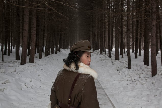 A soldier, working as a guide, walks through a forest that is said to be a former camp site of the late North Korean leader Kim Il Sung; Mount Paektu, NorthKorea, 04 April 2012.