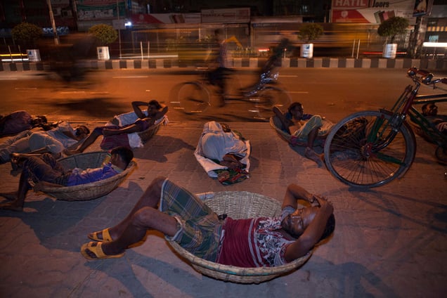 Daily-wage workers sleep on the roadside by the Kawran Bazar in Dhaka. A large number of homeless people in Dhaka have lost their homes and properties through floods, river erosion and other natural calamities, and come to the city in the hope of a better future.