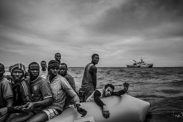 Migrants call out to be rescued from a rubber boat by the MOAS rescue team
