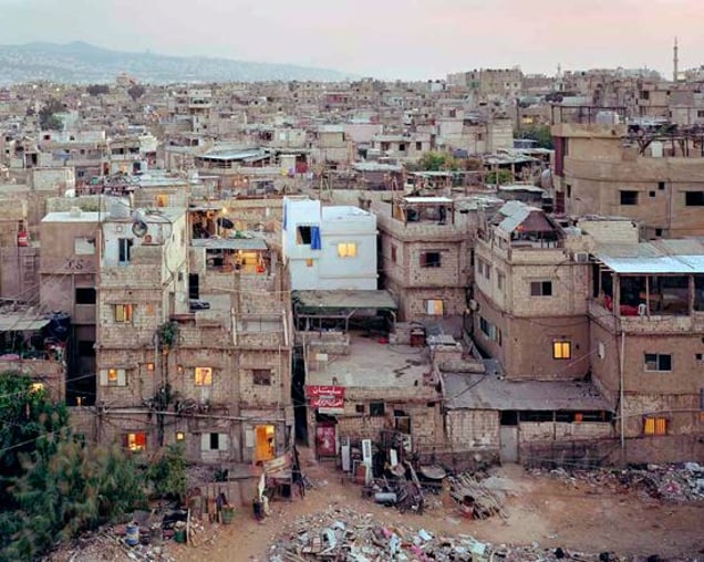 Burj el-Barajneh refugee camp in Beirut. Palestinians have been refugees in Lebanon since 1948. This alleyway leading between the buildings in the centre of this picture, is one of the camps main thoroughfares, which are grossly overcrowded because the government will not allow any expansion of the camp. From "Forensic Traces of War" © Simon Norfolk